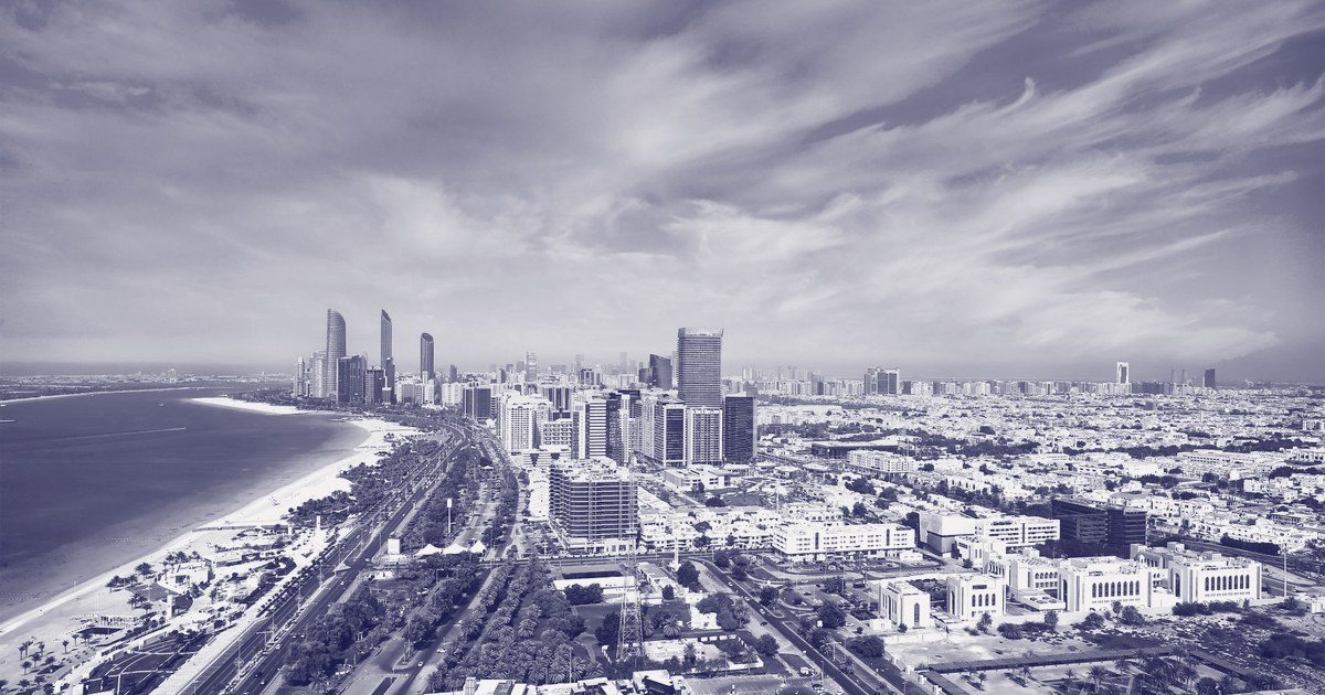 Aerial view of Abu Dhabi's coastal skyline and financial district, with the Corniche beach in the foreground