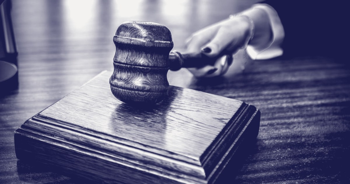 A judge's gavel being brought down on its sound block