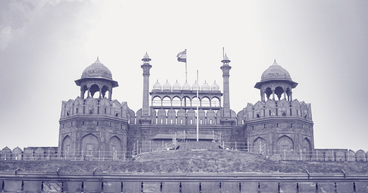 Daytime view of the Red Fort's Lahori Gate facade in Delhi, with the Indian tricolour flying above the ramparts