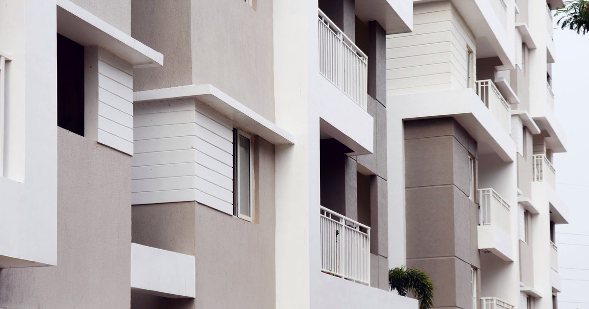 Close-up of a modern white and beige apartment building with balconies in Hyderabad, India