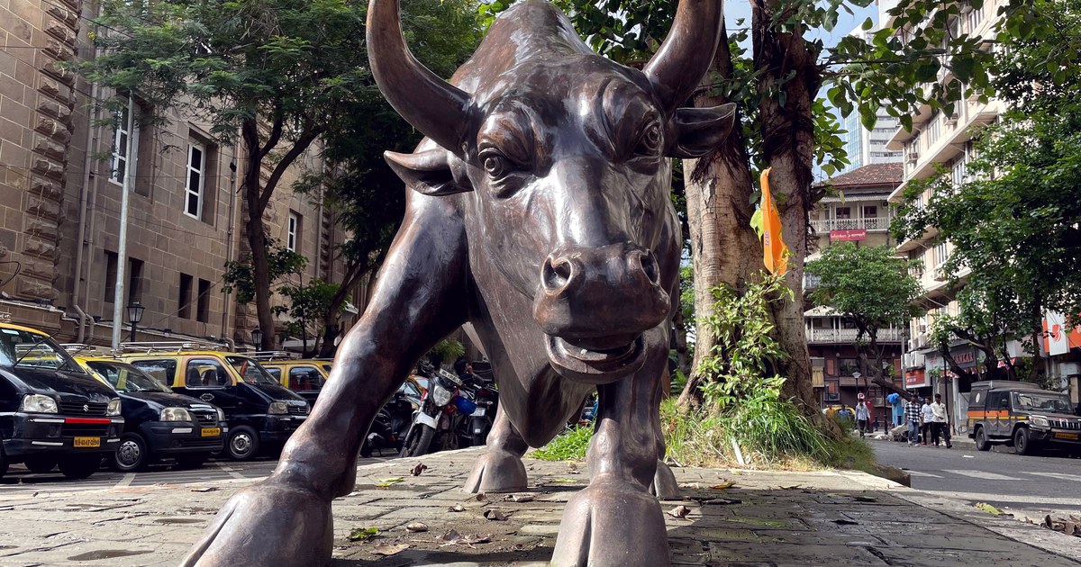 The bronze charging-bull statue near the Bombay Stock Exchange on Dalal Street, Mumbai, with taxis and street traffic behind it