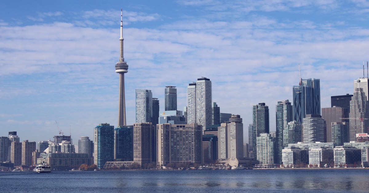 The Toronto skyline and CN Tower seen across the harbour on a clear day, with a ferry boat in the foreground
