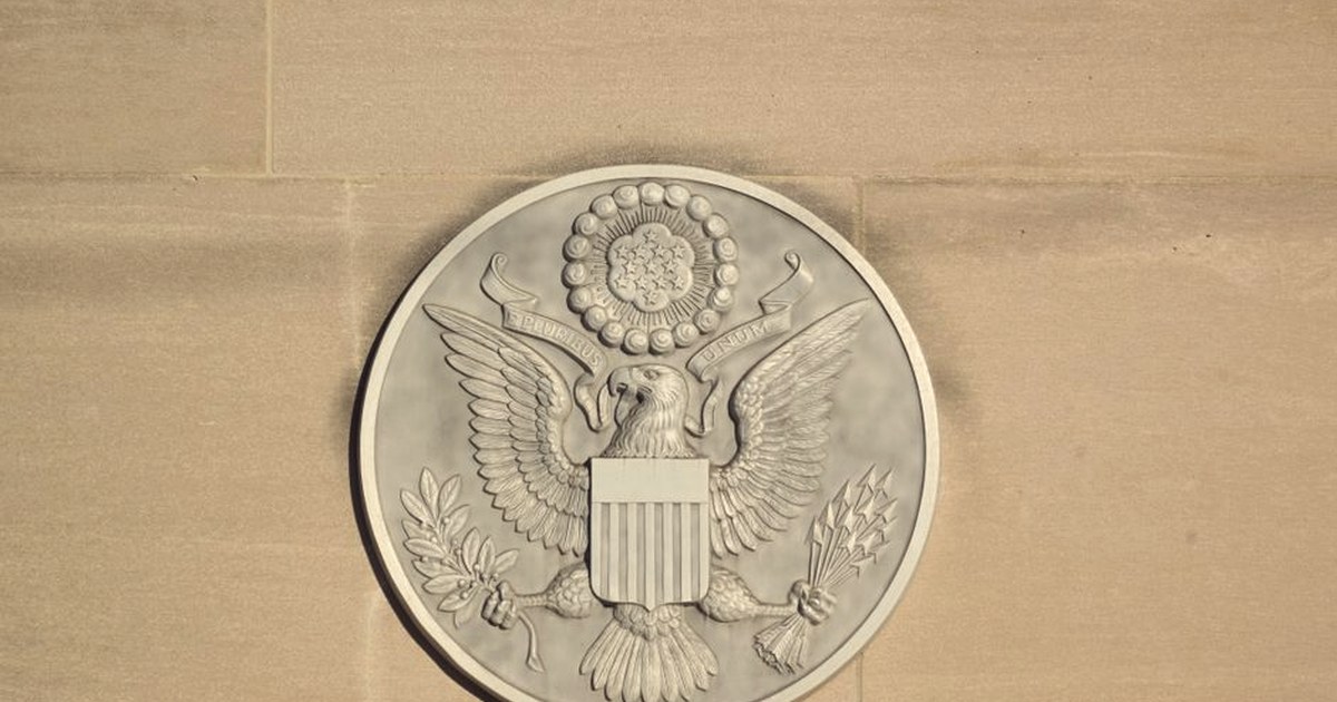 The Great Seal of the United States carved into the stone facade of a federal government building