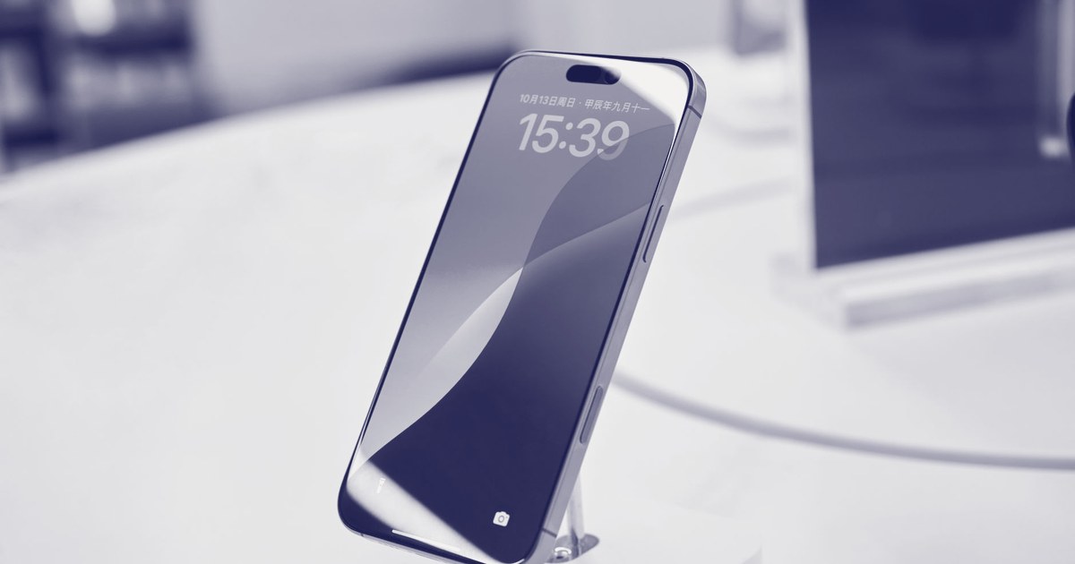 A smartphone on a white display stand in a retail store