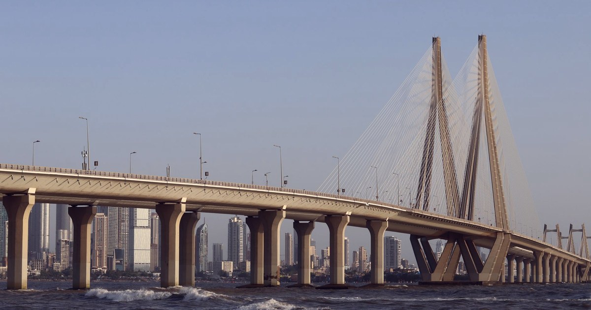 The Bandra-Worli Sea Link in Mumbai, with the city skyline behind it and waves breaking against the bridge's pillars