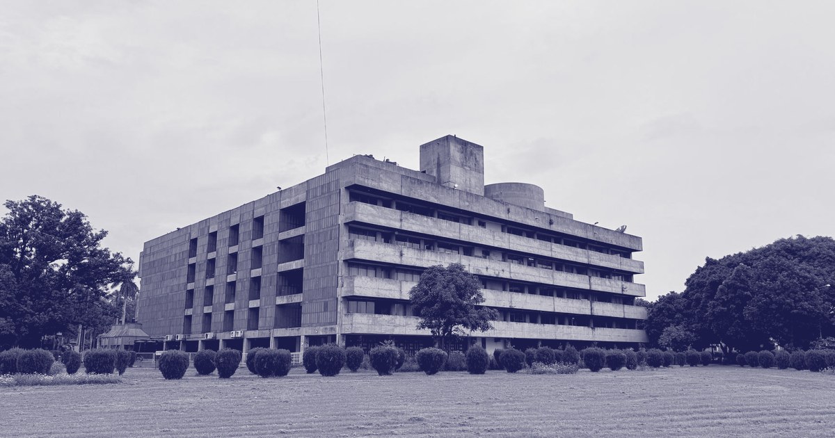 A weathered Brutalist-style government administrative building in Chandigarh, the shared capital city built for Punjab and Haryana, seen across a lawn